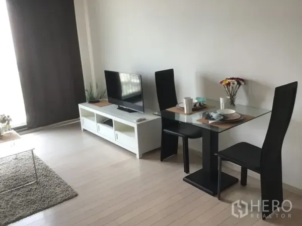 公寓 出租或出售在Watthana, Bangkok - 开放式客厅内的双人用餐角落，毗邻电视柜。