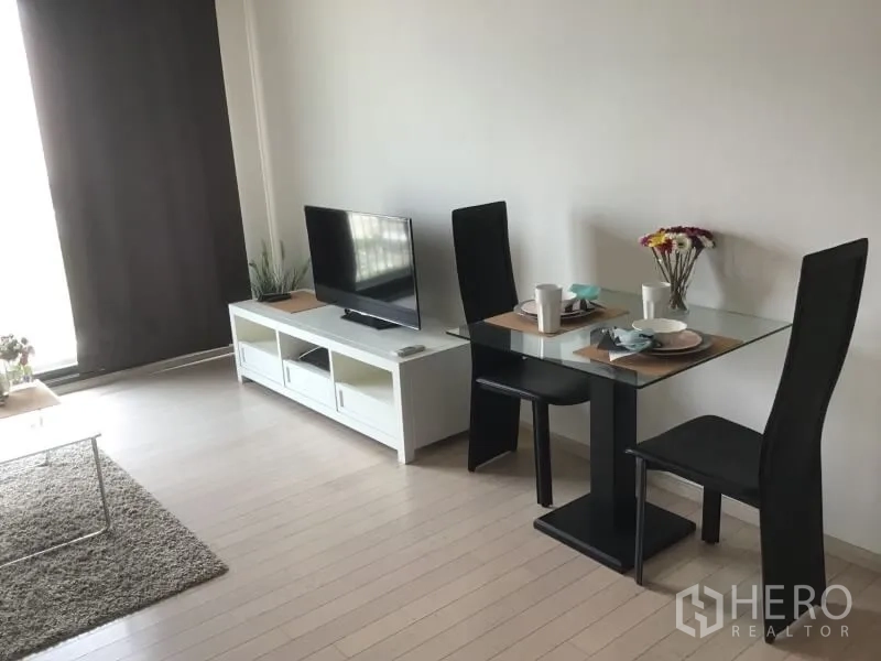 公寓 出租或出售在Watthana, Bangkok - 开放式客厅内的双人用餐角落，毗邻电视柜。