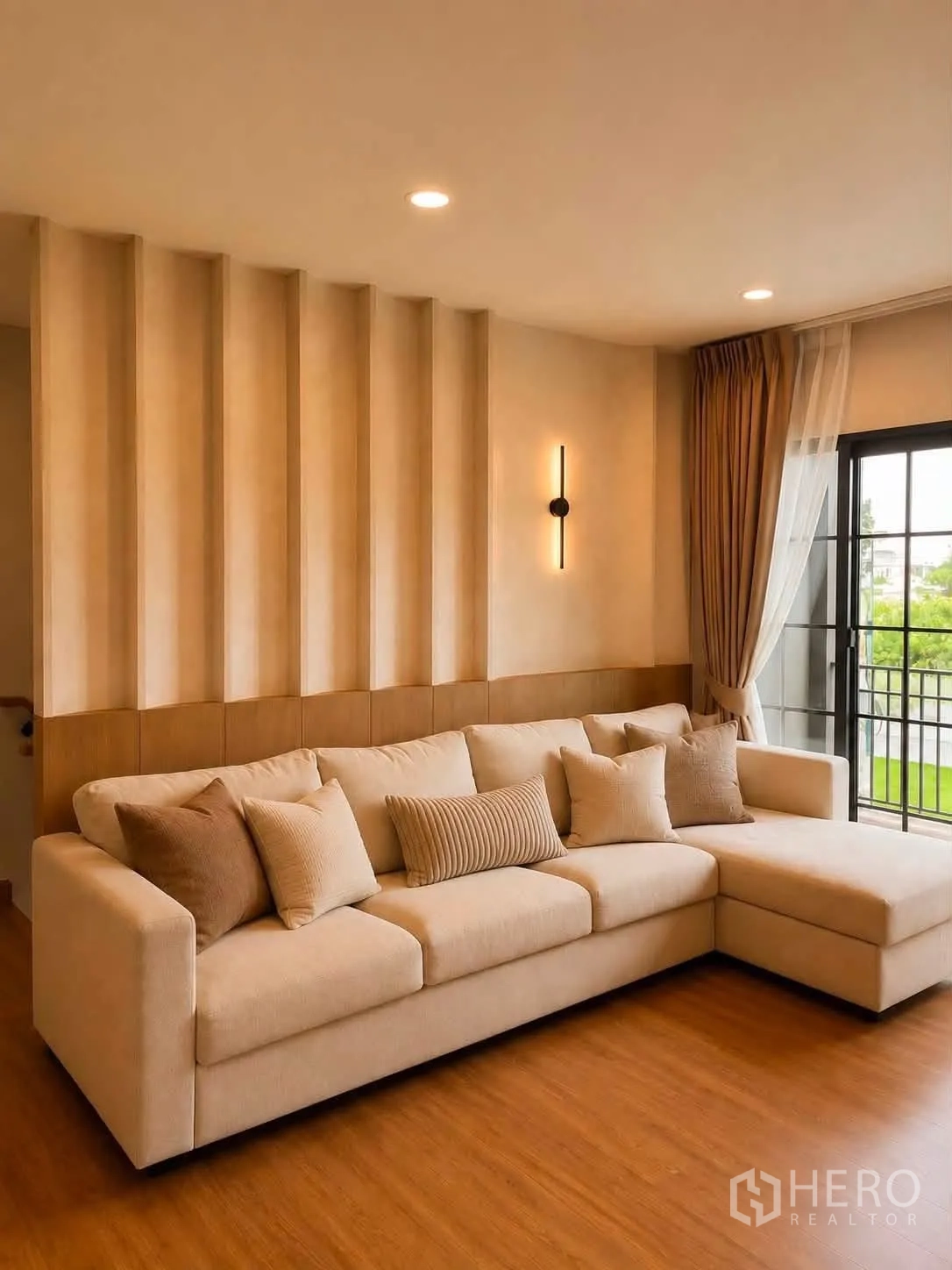 独栋房屋 for rent in Bang Phli, Samut Prakan - 客厅以暖色调为主，L型米色沙发、木质造型墙与推拉门。