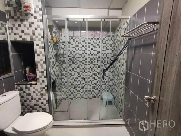 Townhouse for sale in Bang Phlat, Bangkok - Close-up of the walk-in shower with sliding glass doors and patterned tiles.