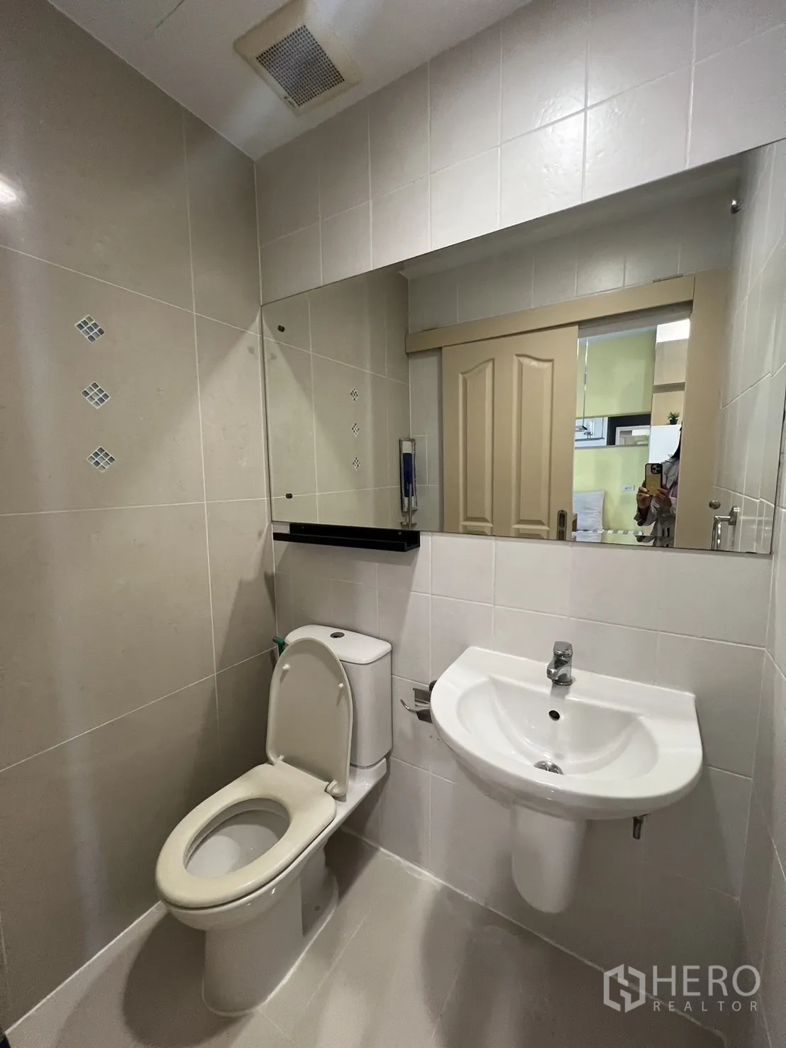 Townhouse for rent in Wang Thonglang, Bangkok - Compact powder room with toilet, sink and wall mirror.