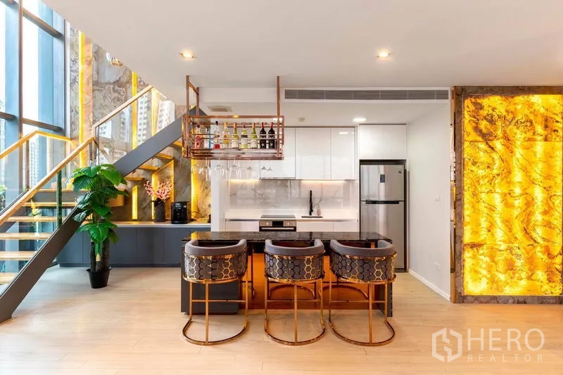 คอนโด ให้เช่าในWatthana, Bangkok - ครัวยุคใหม่ แผงกันเปื้อนหินอ่อน ไอส์แลนด์พร้อมสตูล และผนังหินเรืองแสงสีทอง