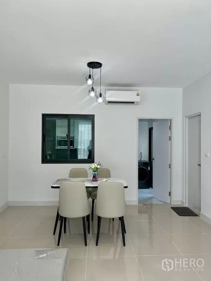 Townhouse for rent in Bang Phli, Samut Prakan - Dining table for four facing a sliding window and air conditioner.