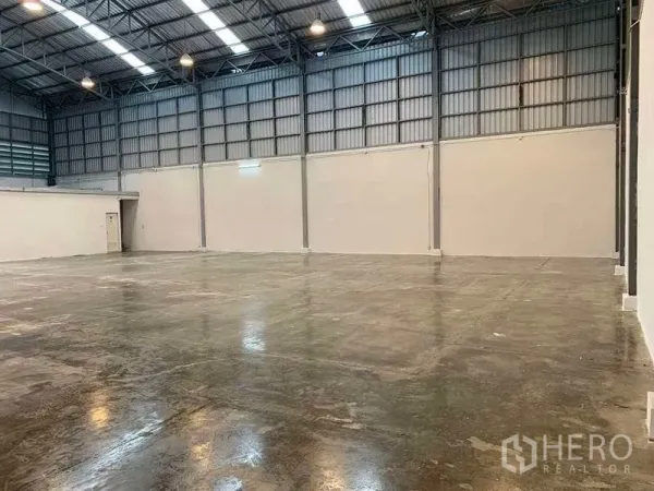货栈 出租在Bang Phli, Samut Prakan - 开阔的储存大厅，配高杆照明、白色隔墙和通风金属板。
