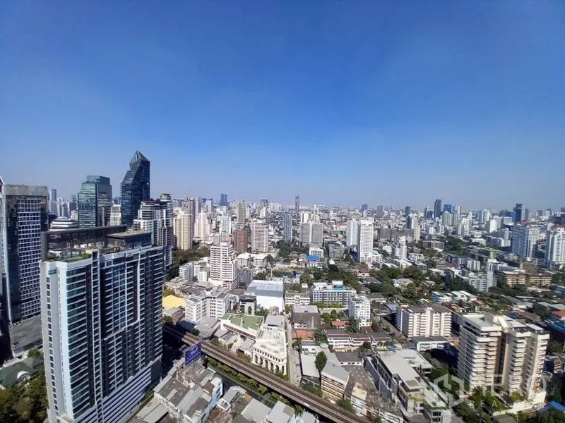 公寓 出租在Khlong Toei, Bangkok - 曼谷高层城市天际线景观，可见轻轨与蓝天。