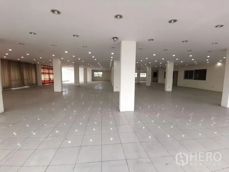 Retail Space for rent in Lam Luk Ka, Pathum Thani - Bright showroom space with many pillars, spotlights and wide aisles on white tiled flooring.