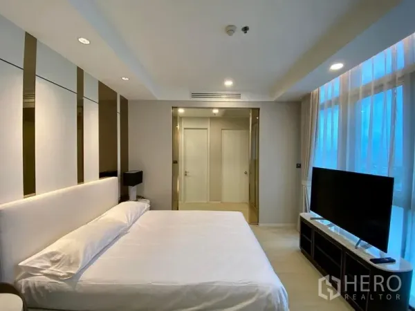 คอนโด ให้เช่าในKhlong Luang, Pathum Thani - ห้องนอนใหญ่เตียงคิง ผนังตกแต่ง ทีวีบิลท์อิน และหน้าต่างสูงจรดเพดานที่ Nusasiri Grand Condo เขตคลองเตย