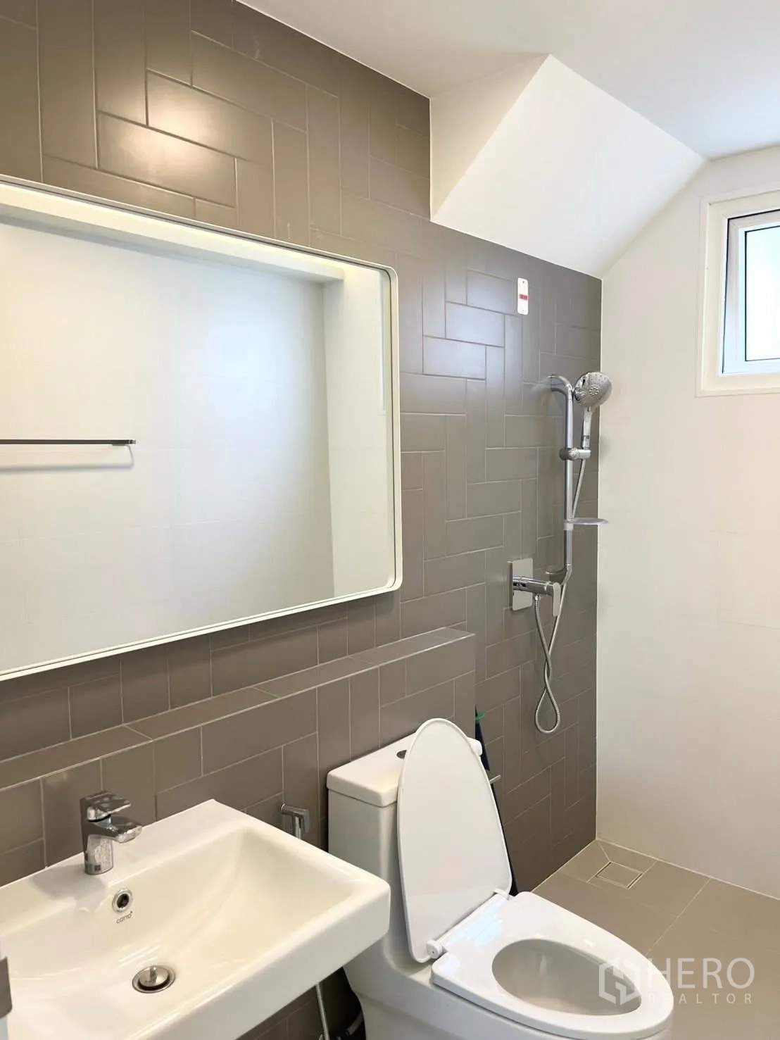 Detached House for rent in Bang Phli, Samut Prakan - Bathroom with toilet, sink, shower set, and gray wall tiles.