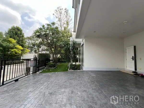 独立式住宅 出租在Saphan Sung, Bangkok - 覆盖式停车区通向前门，旁有侧庭与树木