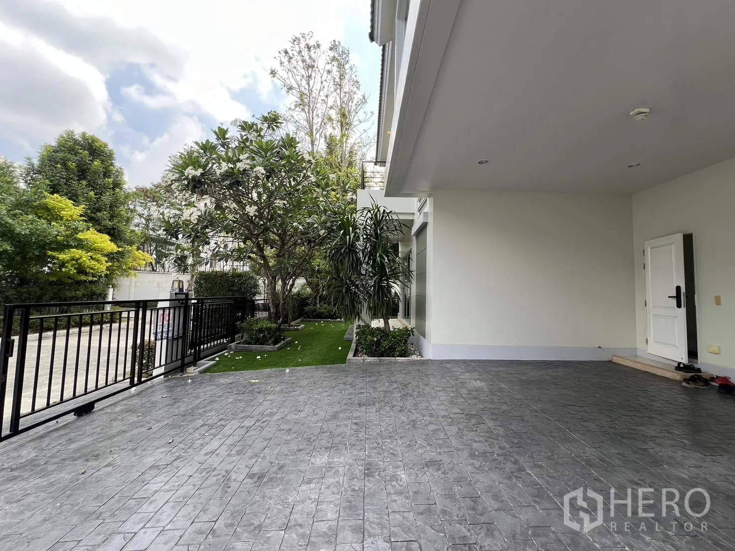 独立式住宅 出租在Saphan Sung, Bangkok - 覆盖式停车区通向前门，旁有侧庭与树木