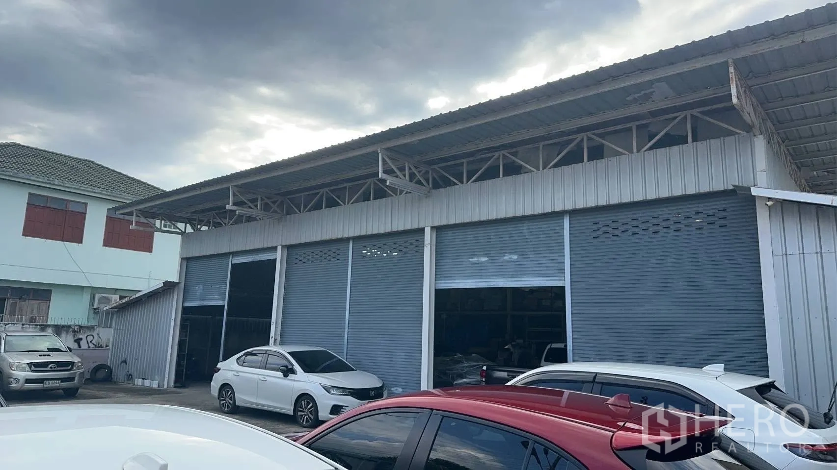 โกดัง for rent in Don Mueang, Bangkok - ด้านหน้าโกดังติดถนน มีประตูม้วนหลายช่อง พร้อมลานจอดรถและพื้นที่ขนถ่ายสินค้า
