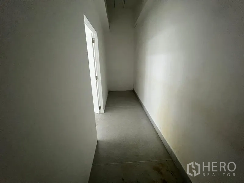 Office Space for rent in Mueang Samut Prakan, Samut Prakan - Dim internal corridor leading to a utility room with a side door.