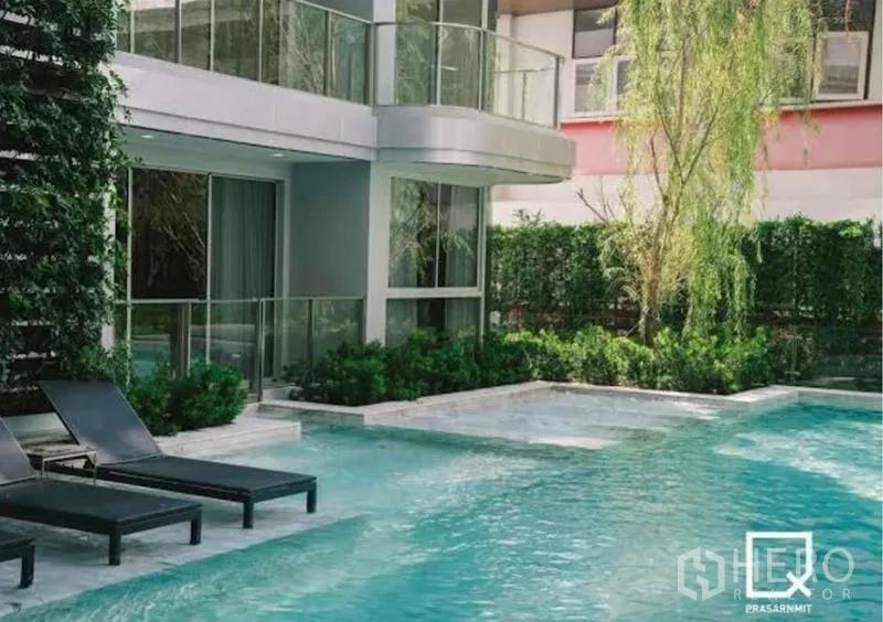 Condominium for rent in Watthana, Bangkok - Poolside corner with balconies, greenery and shallow soaking zone.