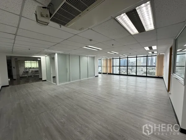 สำนักงาน ให้เช่าในWatthana, Bangkok - ภายในสำนักงานสว่าง พื้นลายไม้ ไฟฝังฝ้า ผนังกั้นกระจก พร้อมมุมมองสกายไลน์ย่านวัฒนา