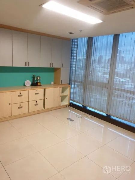 Office Space for rent - Private office with glossy tile floors and built-in storage under a feature wall.