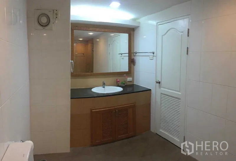 คอนโด ให้เช่าหรือขายในDin Daeng, Bangkok - ห้องน้ำกว้าง เคาน์เตอร์อ่างล้างหน้าท็อปสีดำ กระจกบานใหญ่ และผนังกระเบื้อง.