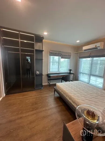 Detached House for rent in Samut Prakan - Bedroom with glass-door wardrobe, writing desk and large windows.