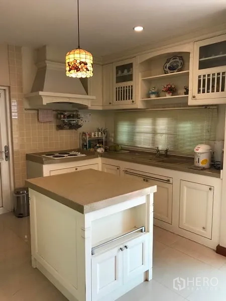 Detached House for sale in Pak Kret, Nonthaburi - Country-style kitchen with island, range hood, open shelving and pendant light.