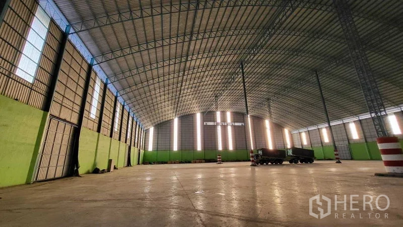 工厂 出租在Sai Noi, Nonthaburi - 内部另一角度，展示高门洞与竖向采光带，空间开阔。