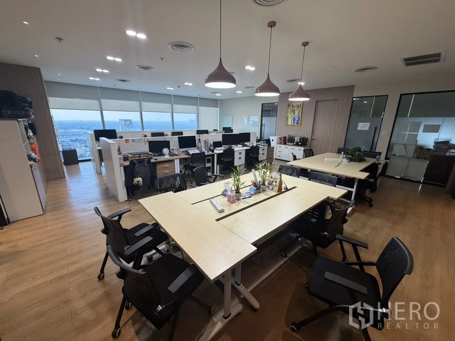 Office Space for rent in Khlong Toei, Bangkok - Open-plan workspace with rows of desks, ergonomic chairs, glass-partitioned rooms, and expansive windows.