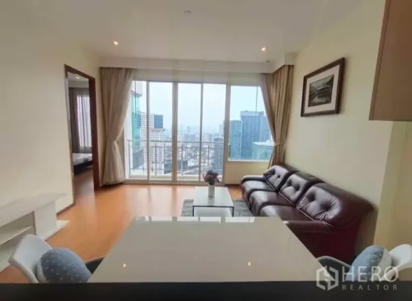 Condominium for rent in Chatuchak, Bangkok - Dining counter facing large glass doors to the balcony and panoramic skyline.