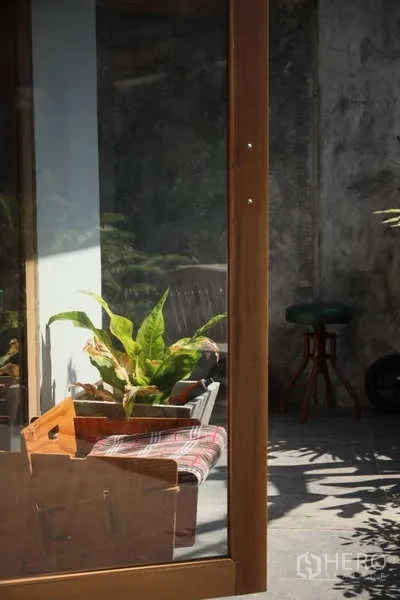 独立式住宅 出租在Lat Phrao, Bangkok - 透过玻璃门眺望带盆栽与高脚凳的荫蔽露台