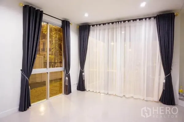 สำนักงานที่บ้าน ให้เช่าหรือขายในBang Khen, Bangkok - มุมห้องรับแขกพร้อมผ้าม่านโปร่งและม่านทึบแบบฟูลฮายท์ ผนังสีขาว