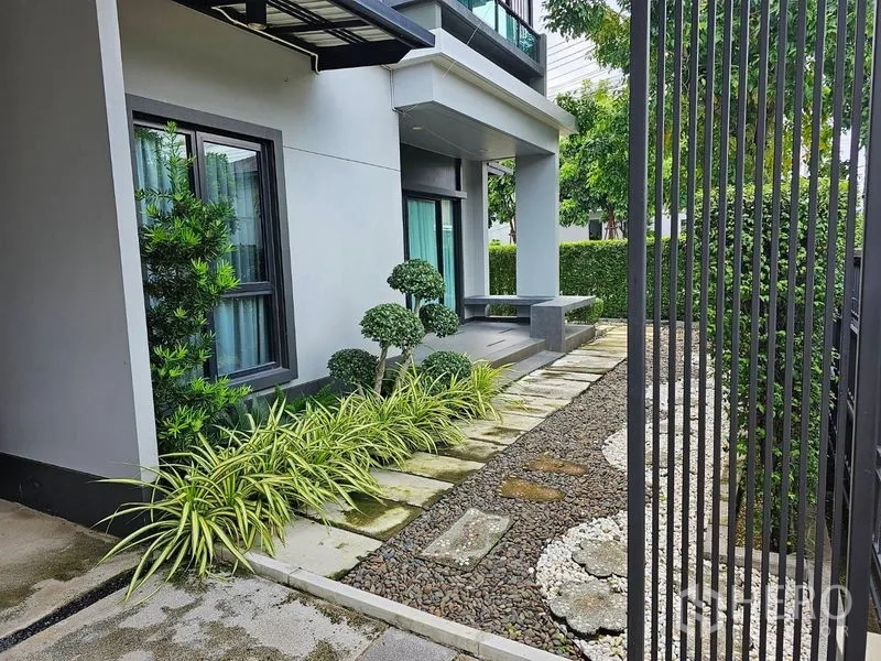 บ้าน ให้เช่าหรือขายในLam Luk Ka, Pathum Thani - สวนหน้าบ้านจัดแต่งพุ่มไม้ ทางเดินหินและระเบียง
