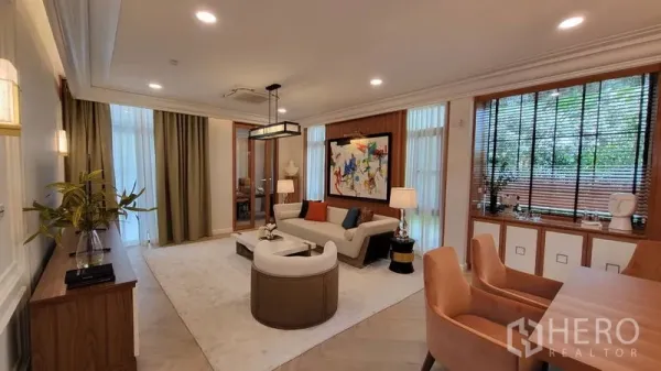 Detached House for rent or sale in Saphan Sung, Bangkok - Spacious living room with floor-to-ceiling windows, wood paneling, and contemporary furniture.