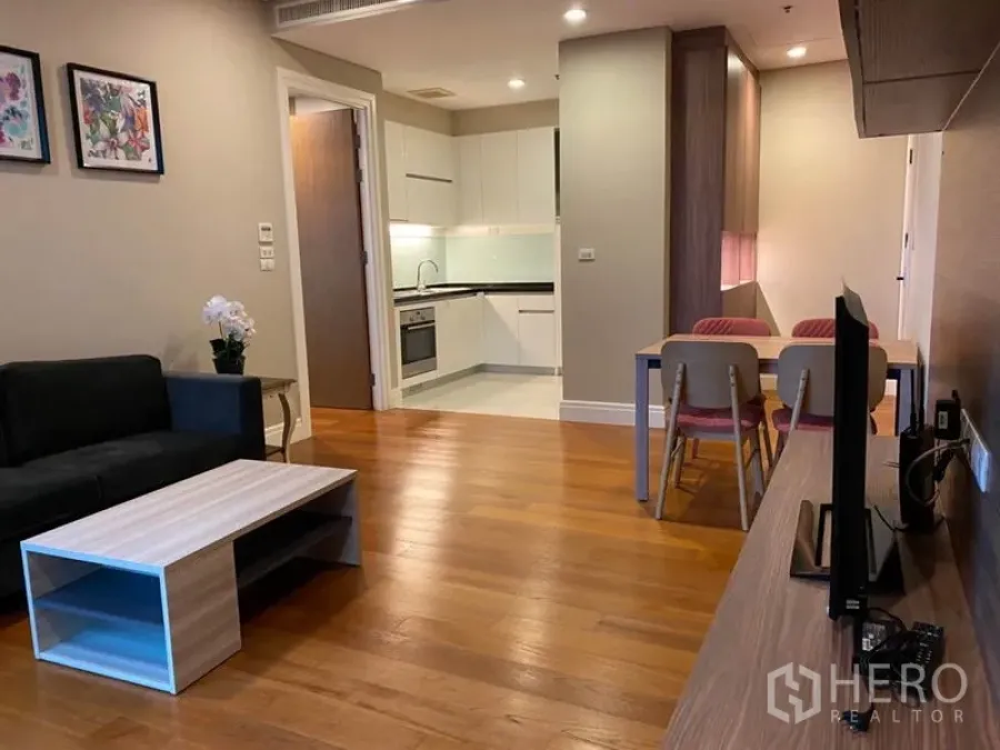 Condominium for rent in Khlong Toei, Bangkok - Spacious lounge with TV console, dining set and connected kitchen.