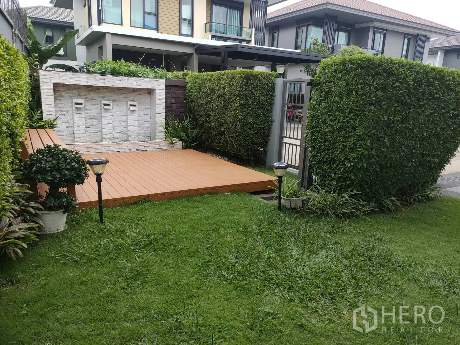 บ้าน ให้เช่าหรือขายในLam Luk Ka, Pathum Thani - สวนมุมจัดแต่งพร้อมระเบียงไม้และผนังหินตกแต่งมีสายน้ำ