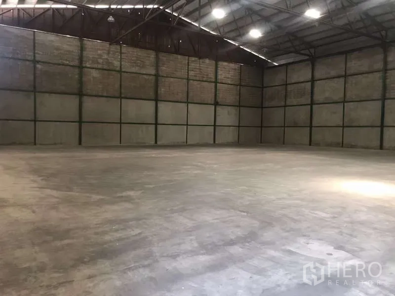 工厂 出租在Bang Pakong, Chachoengsao - 宽阔空旷的厂房，混凝土地面，钢桁架屋顶与明亮照明。