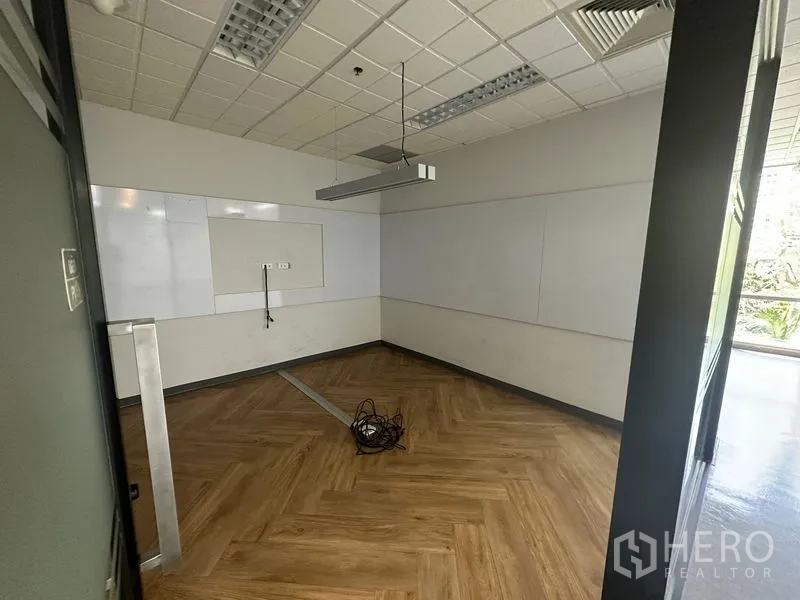 Office Space for rent - Private office with whiteboards on the walls, herringbone flooring and hanging light fixture.