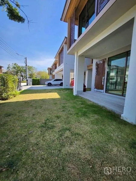 บ้าน ขายในSai Mai, Bangkok - สนามหญ้าหน้าบ้านและเฉลียงมีหลังคา พร้อมประตูกระจกบานเลื่อนขนาดใหญ่