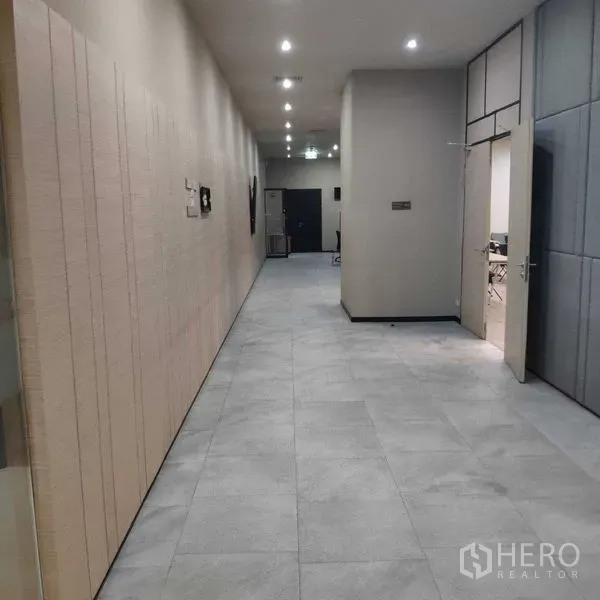 办公空间 出租 - 宽敞走廊，灰色地砖与嵌入式筒灯。