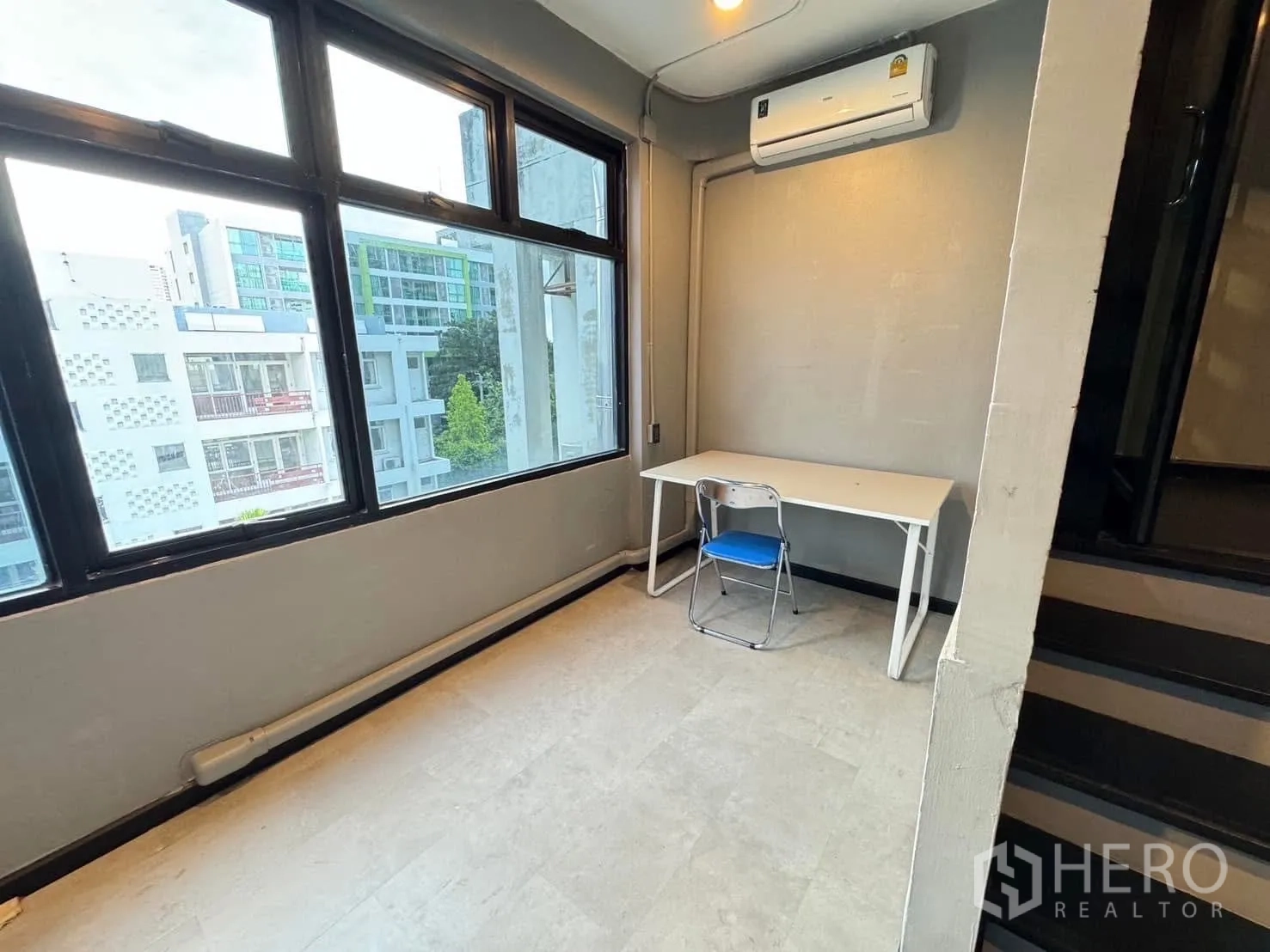 家庭办公室 for rent in Watthana, Bangkok - 转角工作位，大窗、书桌与壁挂空调。
