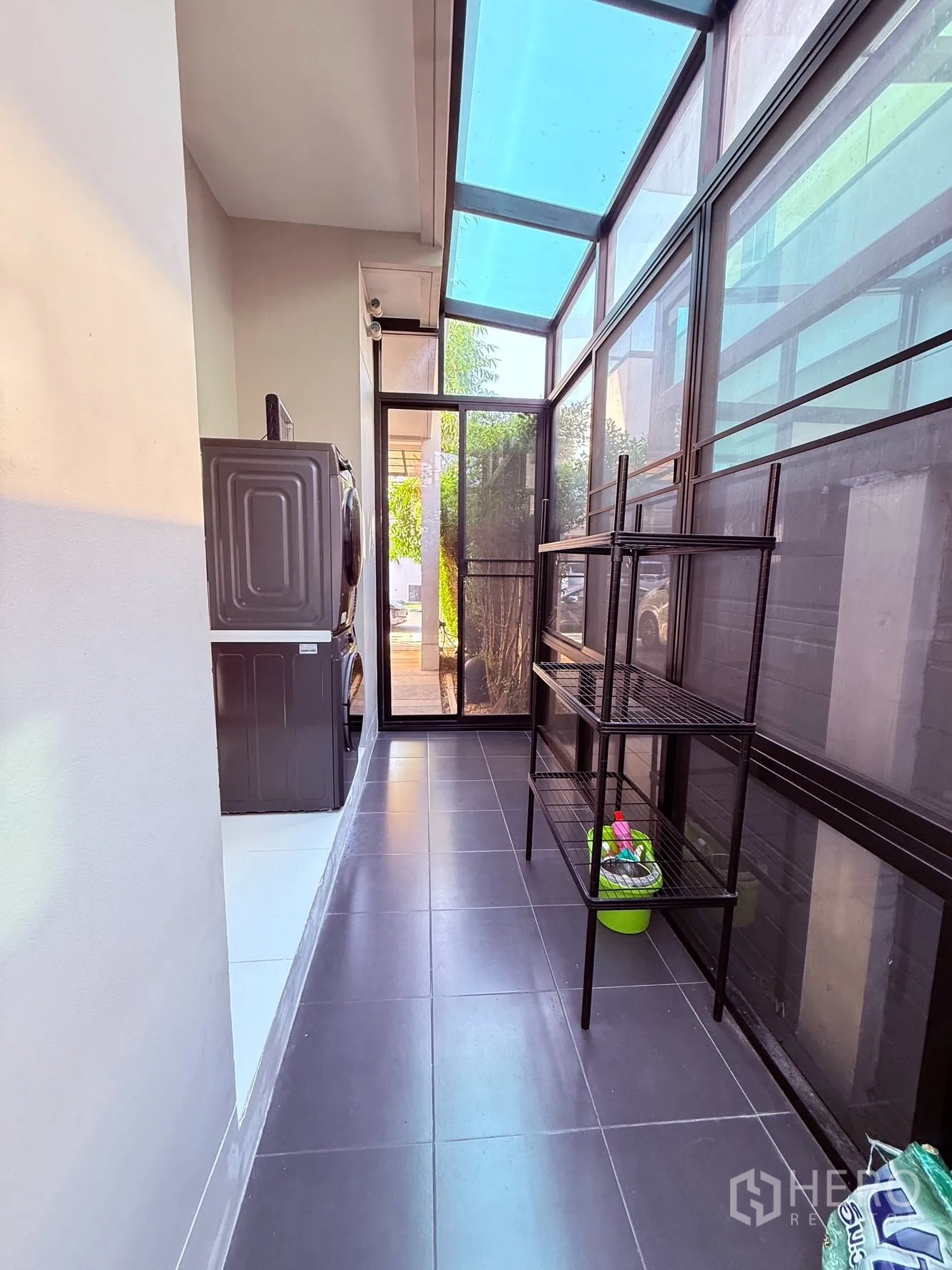 บ้านเดี่ยว for rent or sale in Prawet, Bangkok - พื้นที่ซักรีดปิดกระจกมีหลังคาโปร่ง เครื่องซักผ้าอบผ้า และชั้นเหล็กจัดเก็บของ.