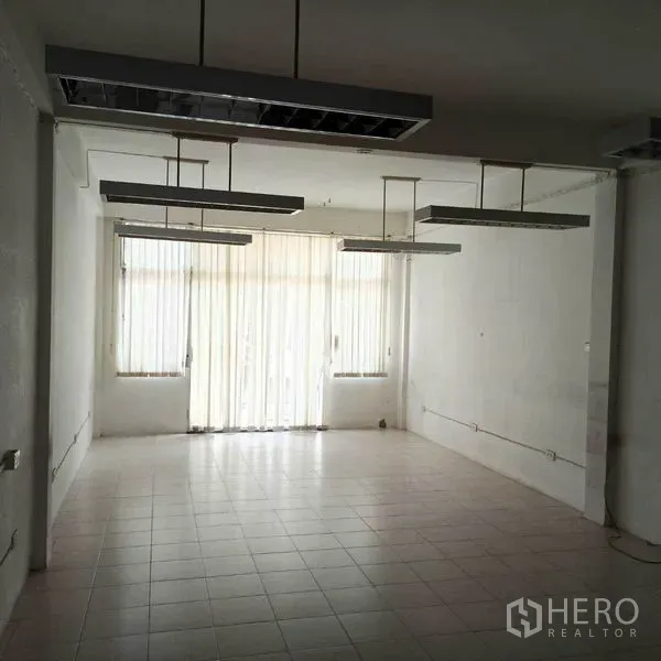 อาคารพาณิชย์ ให้เช่าในKhlong Toei, Bangkok - พื้นที่เปิดโล่งพร้อมโคมไฟฟลูออเรสเซนต์แขวนและม่านบังแสงเต็มผนัง