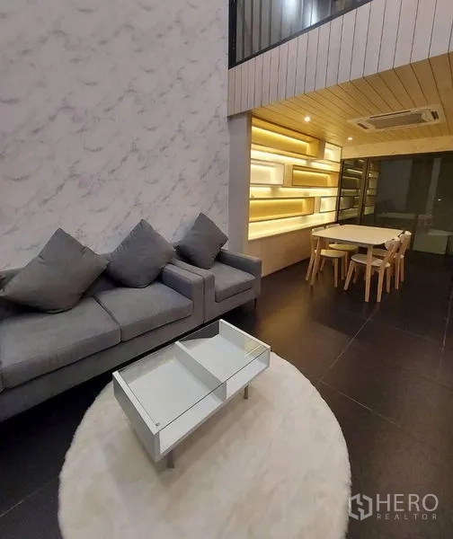 联排别墅 出租在Thanyaburi, Pathum Thani - 开放式起居与餐区，灰色沙发，背光层架与木质天花