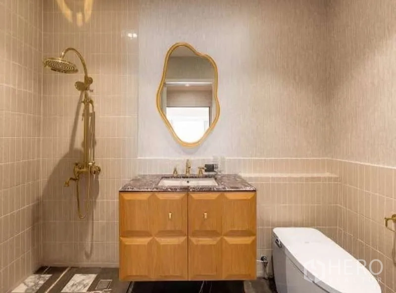 Townhouse for sale in Sathon, Bangkok - Stylish bathroom with gold rain shower, marble-top vanity and curved mirror.