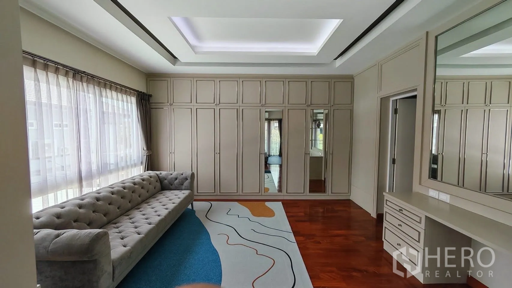 Detached House for rent or sale in Bang Phli, Samut Prakan - Dressing room with full-height wardrobes, a long sofa, and a makeup counter.