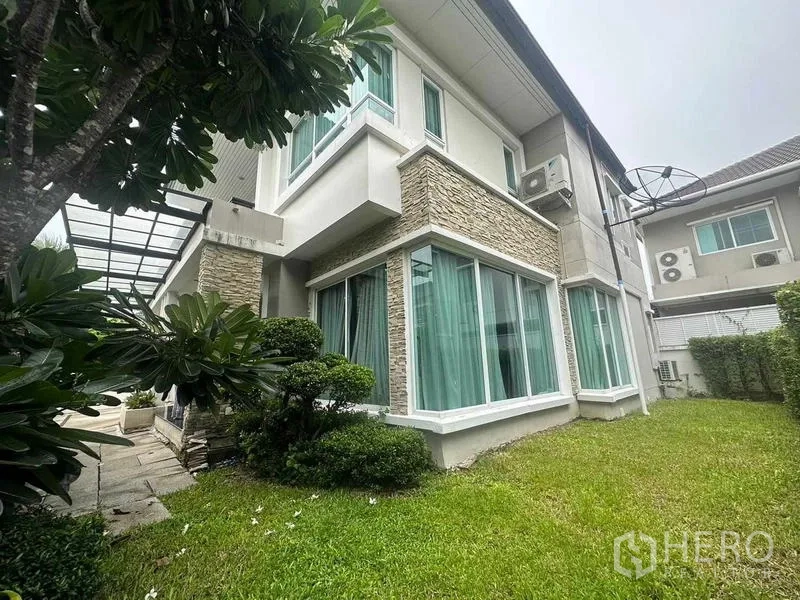 Detached House for sale in Saphan Sung, Bangkok - Corner of the house with floor-to-ceiling windows and a private lawn with trees.