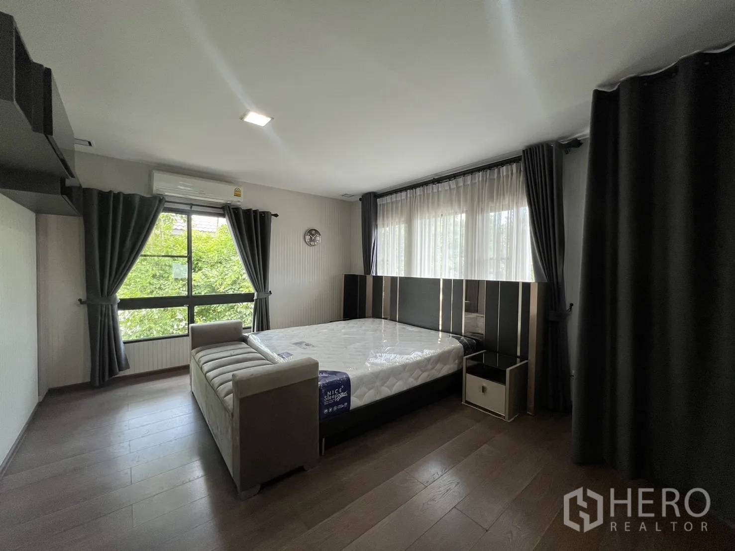 Detached House for rent in Bang Phli, Samut Prakan - Large master bedroom with corner windows, bed and bench seat.