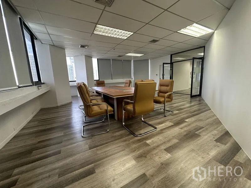 办公空间 出租或出售在Din Daeng, Bangkok - 会议室配方形会议桌、棕色椅子与现代木纹地面。