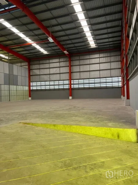 Warehouse for rent in Pathum Thani - Loading ramp leading to an open warehouse floor with ventilation louvers.