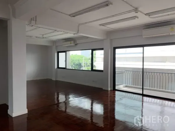 办公空间 出租在Watthana, Bangkok - 宽敞工作区，配空调与吊顶照明，落地窗通向阳台。