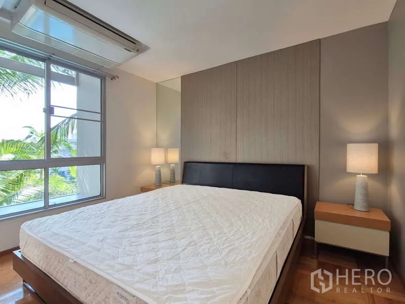 Condominium for rent in Yan Nawa, Bangkok - Bedroom with large window, upholstered headboard and bedside lamps.