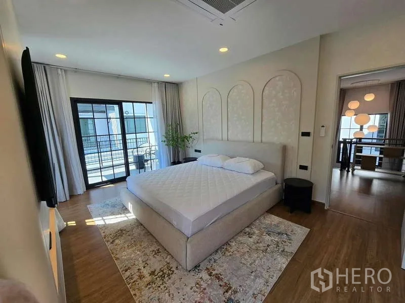 Detached House for rent in Bang Phli, Samut Prakan - Bright master bedroom with king bed, balcony access and wood floors.
