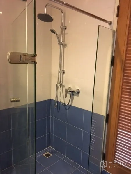 คอนโด ให้เช่าในPathum Wan, Bangkok - ห้องน้ำมีตู้กระจกอาบน้ำ ฝักบัวเรนชาวเวอร์ และกระเบื้องสีน้ำเงิน-ขาว