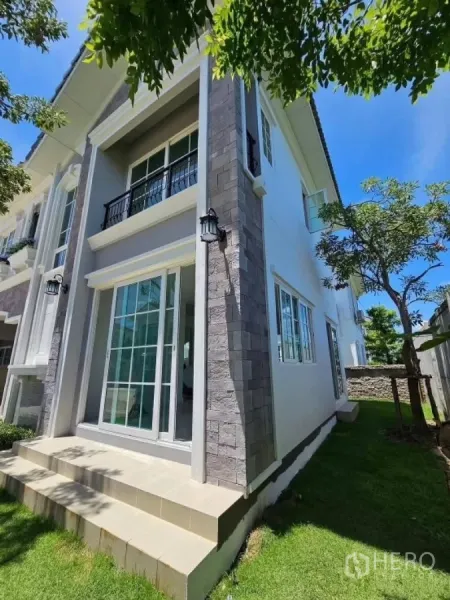 Detached House for rent in Thanyaburi, Pathum Thani - Corner view highlighting tall columns, terrace steps and large glass doors.